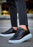 Black high-top sneakers with white soles worn by a person on a blurred background