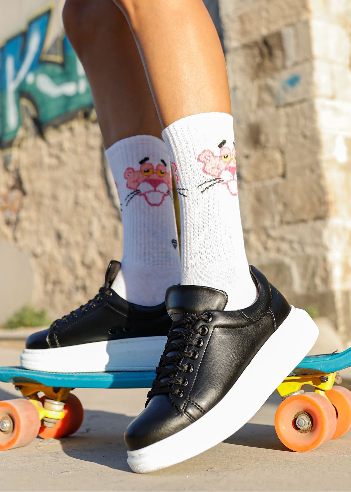 Women's Pluto Shadow Black slip-on sneaker in black by Apollo Moda, worn on a skateboard